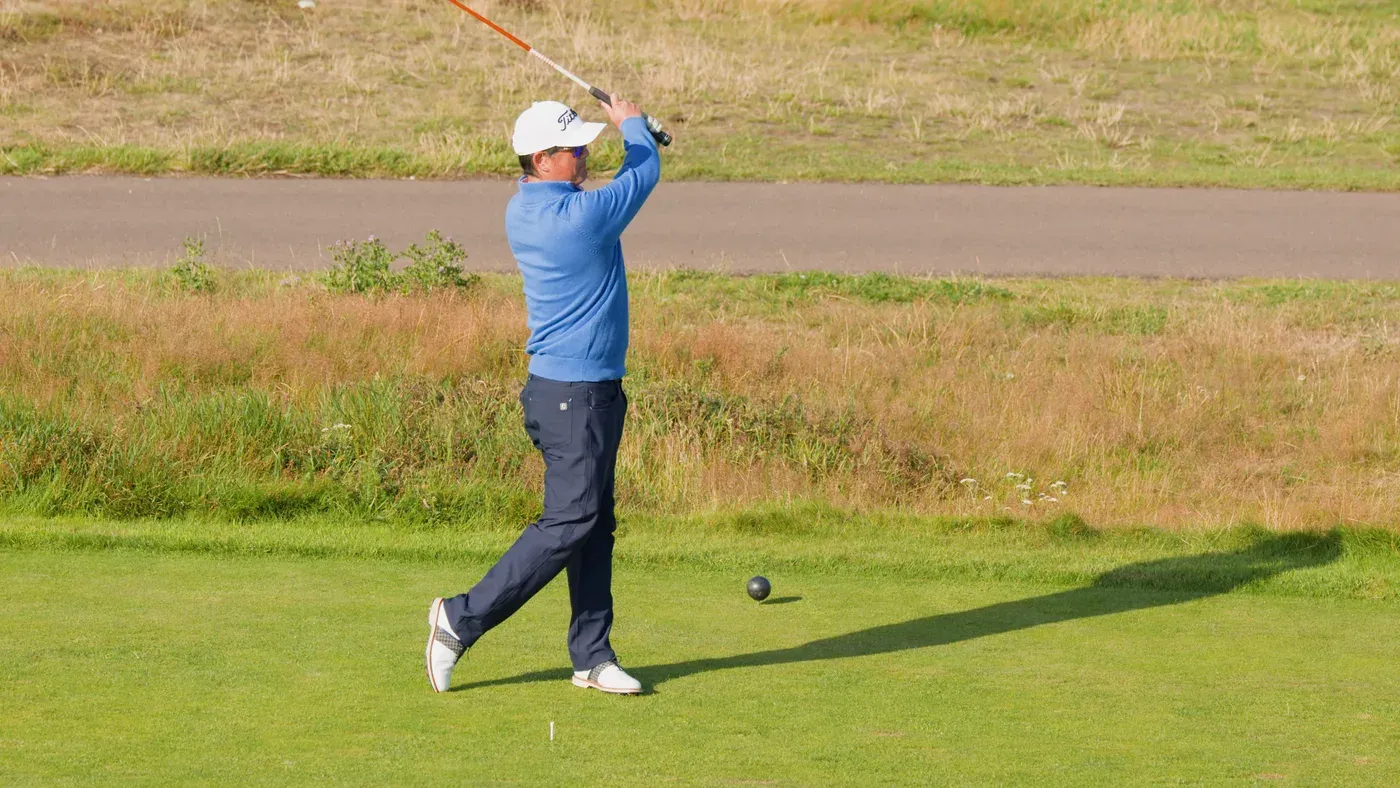 Golfare som avslutar ett slag med drivern