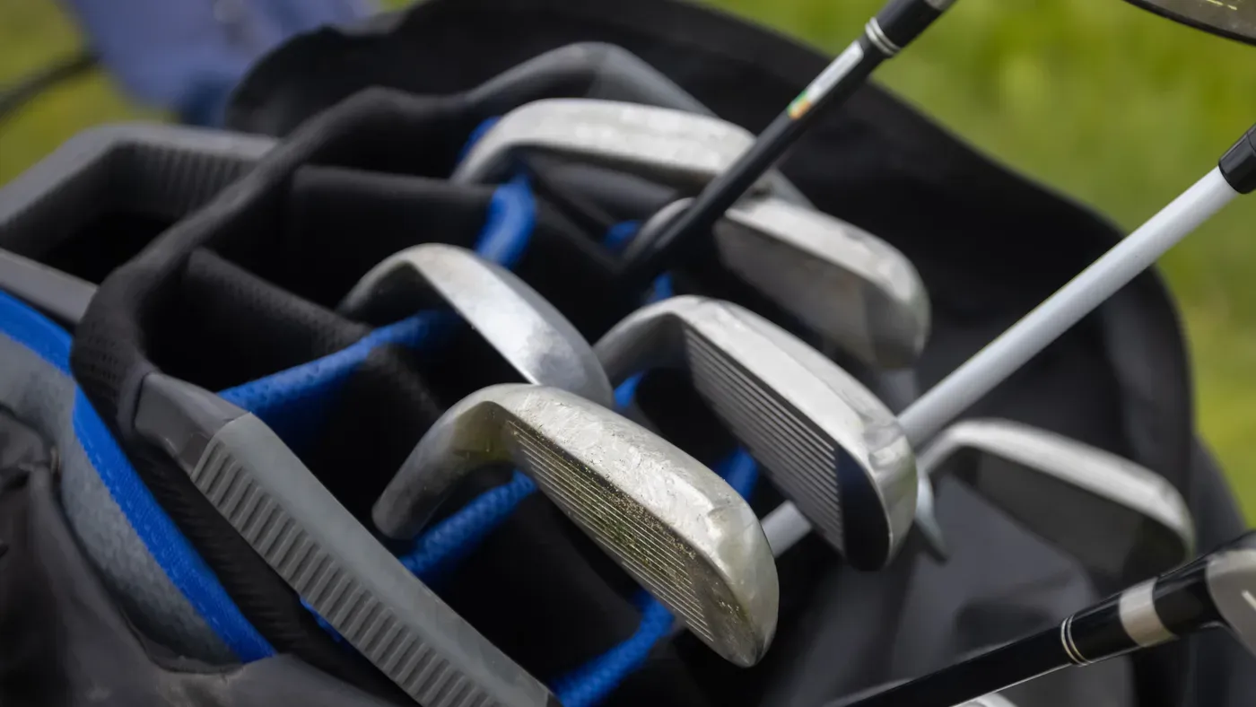 Järnklubbor som står i fack i en golfbag